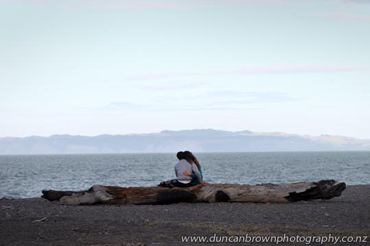 Young love, couple on a log, Pacific Beach, Marine Parade, Napier photograph